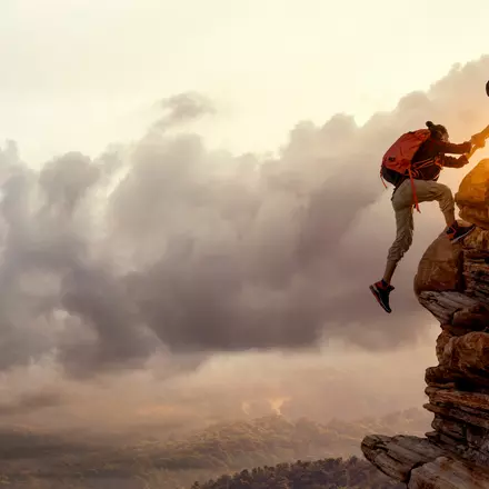 Bilden visar två personer som klättrar på ett berg