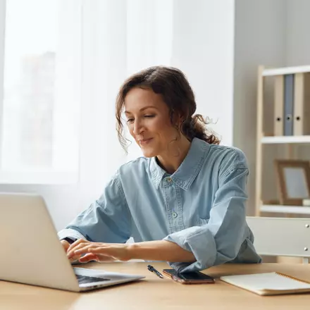 Bilden visar en kvinna som attesterar fakturor i sin dator