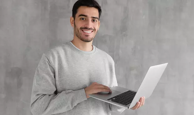 Bilden visar en man med en dator