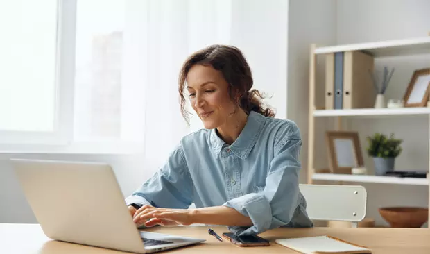 Bilden visar en kvinna som jobbar vid en dator
