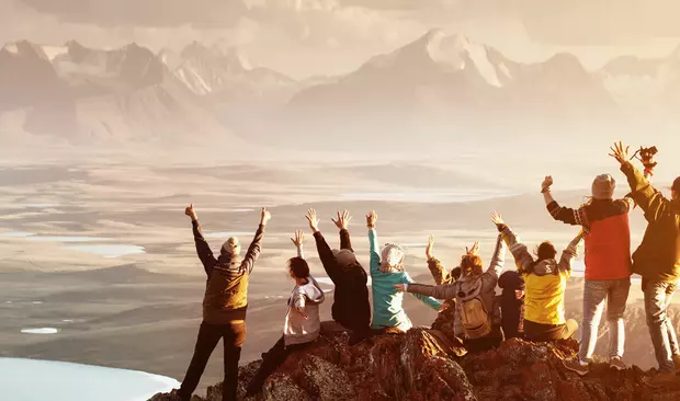 Bilden visar ett team som nått toppen av ett berg
